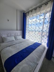 Ένα ή περισσότερα κρεβάτια σε δωμάτιο στο TVHStays Cozy 1-BEDROOM Roysambu