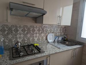 a kitchen counter with a stove and a sink at Beautiful apart with sea view in Tangier