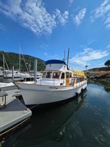 a white boat is docked at a dock at Dockside Boat Rental Suite Rosario Ocean Views in Eastsound