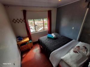 a small bedroom with a bed and a window at Hostal Música y Arte in San Agustín