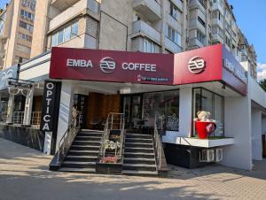 a coffee shop with a staircase in front of a building at Black and White apartment in Chişinău