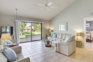 a living room with couches and a glass table at Golf and Swim Country Club Condo in Palm Desert in Palm Desert