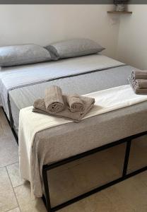 Una cama con toallas encima. en La Casedda, en Carovigno