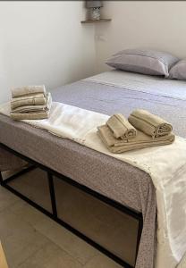 Una cama con toallas encima. en La Casedda, en Carovigno