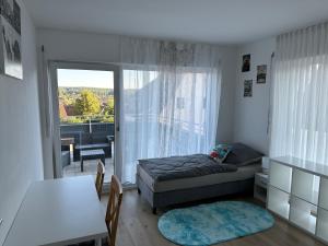 a bedroom with a bed and a table and a window at Guest House BiBi-Lux in Ilsfeld