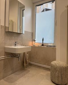 une salle de bain avec un lavabo et une grande fenêtre dans l'établissement Grand Apartment Worms - Stilvolles Wohnen im Zentrum, à Worms