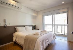 ein Schlafzimmer mit einem großen Bett mit Handtüchern darauf in der Unterkunft BHomy Apm in São Paulo + 73 Fotos