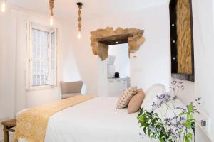 a white bedroom with a bed and a window at Santo Copas in Seville