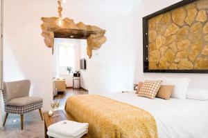 a bedroom with a bed and a stone wall at Santo Copas in Seville