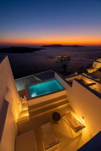 a villa with a swimming pool at sunset at Aesthesis Boutique Villas Fira in Fira
