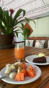 a table with two plates of food and a glass of orange juice at Pousada São Jorge in Bonito
