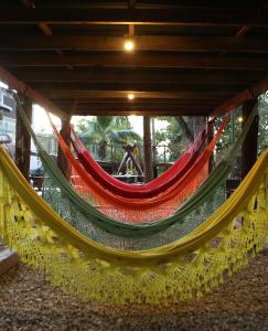 a group of hammocks hanging from a building at Pousada Sol do Araguaia in Barra do Garças