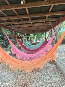an orange and pink hammock hanging under a roof at Pousada Sol do Araguaia in Barra do Garças