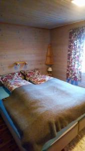 a bedroom with a large bed with wooden walls at Renovated Cabin By Lake Djupedal in Bygstad