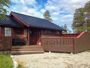 a log cabin with a porch and a deck at Renovated Cabin By Lake Djupedal in Bygstad
