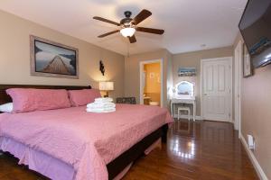 a bedroom with a pink bed and a ceiling fan at Family Friendly Close of Strip Hot Tub and Driveway in Las Vegas +53 photos