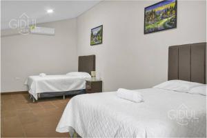 サンタ・アナにあるCozy Bedroom in a coffee farmn in Coatepeque Lakeの白い壁の部屋にベッドが2つある