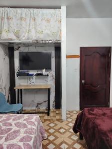 プエルト・バケリソ・モレノにあるCuarto en galápagosのベッドとテレビ付きの机のある寝室 +11枚の写真