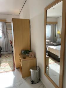 a bedroom with a bed and a mirror in a room at Apart-Hotel Vila Mariana in Sao Paulo