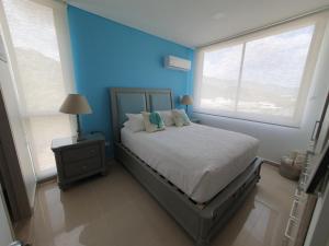 a bedroom with a bed and a blue wall at Beachfront Family Escape 3BR Samaria Club de Playa in Gaira +66 photos