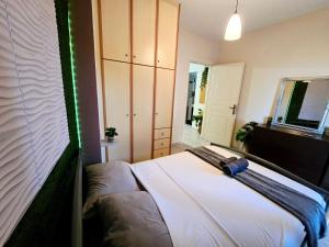 a bedroom with a large white bed with green lights at The Green studio - Garden view in Lamía