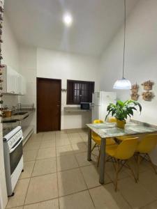 a kitchen with a table and yellow chairs in it at Villa Bajaú in Serra do Cipo +44 photos