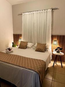 a bedroom with a large bed with a window at Villa Bajaú in Serra do Cipo