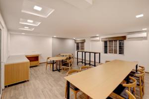Super Townhouse Siri Residency في بانغالور: فصل دراسي يحتوي على طاولات وكراسي في الغرفة