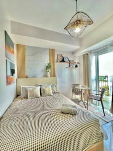 a bedroom with a large bed and a table at Casa Amalia by Casa Mira Mandaue in Mandaue City