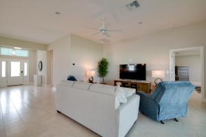 a living room with a white couch and a tv at Golf and Swim in The Villages! Modern Home with Lanai in Wildwood