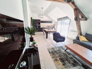 a living room with a couch and a table at Appartement Spa et Terrasse in Dijon
