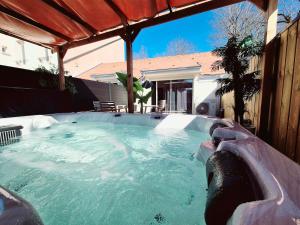 a hot tub in a backyard with a house at Appartement Spa et Terrasse in Dijon