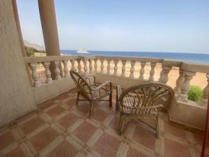 two chairs and a table on a balcony overlooking the ocean at Blue view villas in Dahab