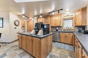 ベールにあるCentral Vail Stay Cozy Interior Deck Viewsのキッチン(木製キャビネット、黒いカウンタートップ付)