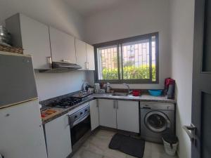 eine Küche mit Spüle und Waschmaschine in der Unterkunft Appart Ennakhil 4 avenue mohamed 6 in El Jadida