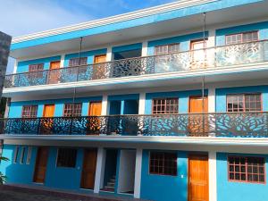 ein Mehrfamilienhaus mit orangefarbenen Türen und Balkon in der Unterkunft Hotel Hormiguero in Xpujil