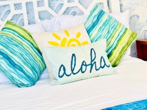 a bed with pillows with the word aloha on it at Sweet Blue Hawaii in Honolulu