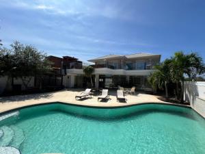 a large swimming pool in front of a house at Búzios Mansion Canal Area in Búzios