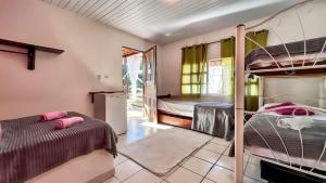 a bedroom with two bunk beds and a kitchen at Pousada e Hostel Da Rosa in Pipa