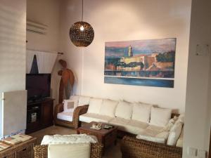 a living room with a white couch and a painting at Vila Ceder in Krk