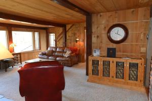 a living room with a couch and a clock on the wall at Seasons at McCall by Casago McCall - Donerightmanagement in McCall