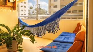 a hammock on a balcony with a plant at Apartamento em Barra dos Coqueiros a 300m da praia in Barra dos Coqueiros