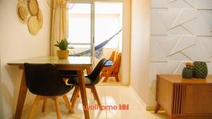 a dining room with a table and chairs and a window at Apartamento em Barra dos Coqueiros a 300m da praia in Barra dos Coqueiros
