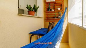 a blue hammock in a room with a chair at Apartamento em Barra dos Coqueiros a 300m da praia in Barra dos Coqueiros +15 photos