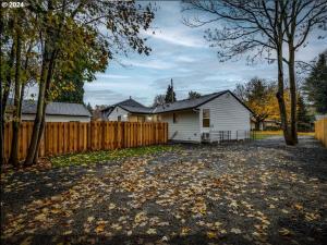 a white house with a fence in the yard at Cozy 2BR - Backyard Fun and Dog Friendly - sleeps 6 in Vancouver