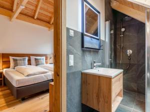 Un baño con lavabo y una cama en una habitación. en Mountain Chalet Alpinchique 2, en Sankt Lorenzen ob Murau