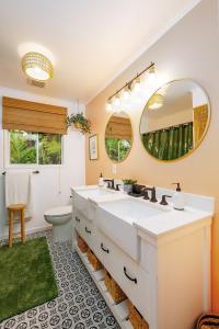 a bathroom with a sink and a toilet and a mirror at Lihau Boho House in Kailua-Kona
