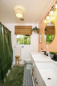 a bathroom with a sink and a toilet and a mirror at Lihau Boho House in Kailua-Kona +144 photos