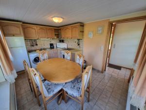 a kitchen with a table and chairs and a refrigerator at Pugholz XL in Hasselberg +14 photos