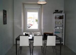 a dining room with a table and white chairs at O Forte Guest House in Peniche +21 photos